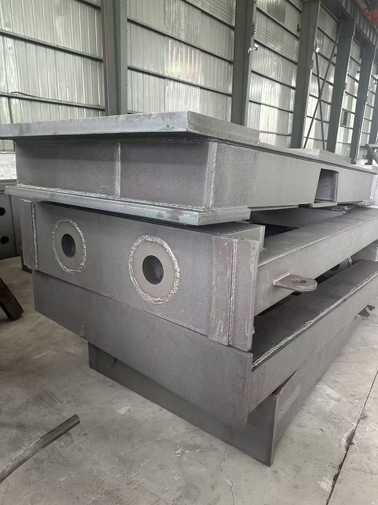 Shot-blasted custom steel weldments stacked in the BECO workshop