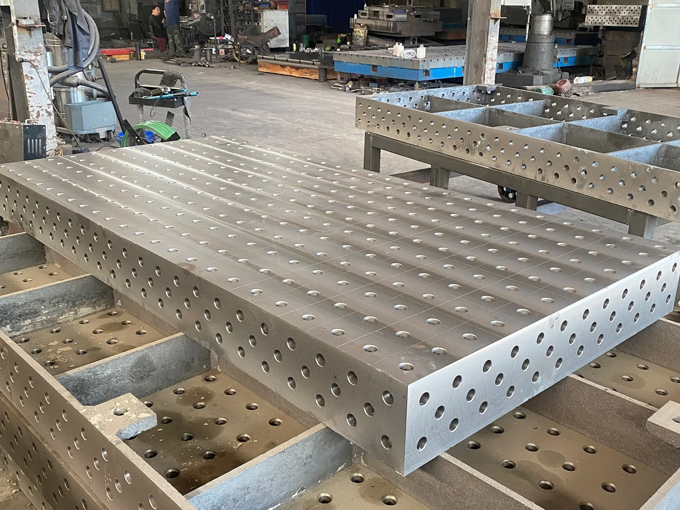 Machined 3D welding platform showing the hole grid carried onto the vertical side face